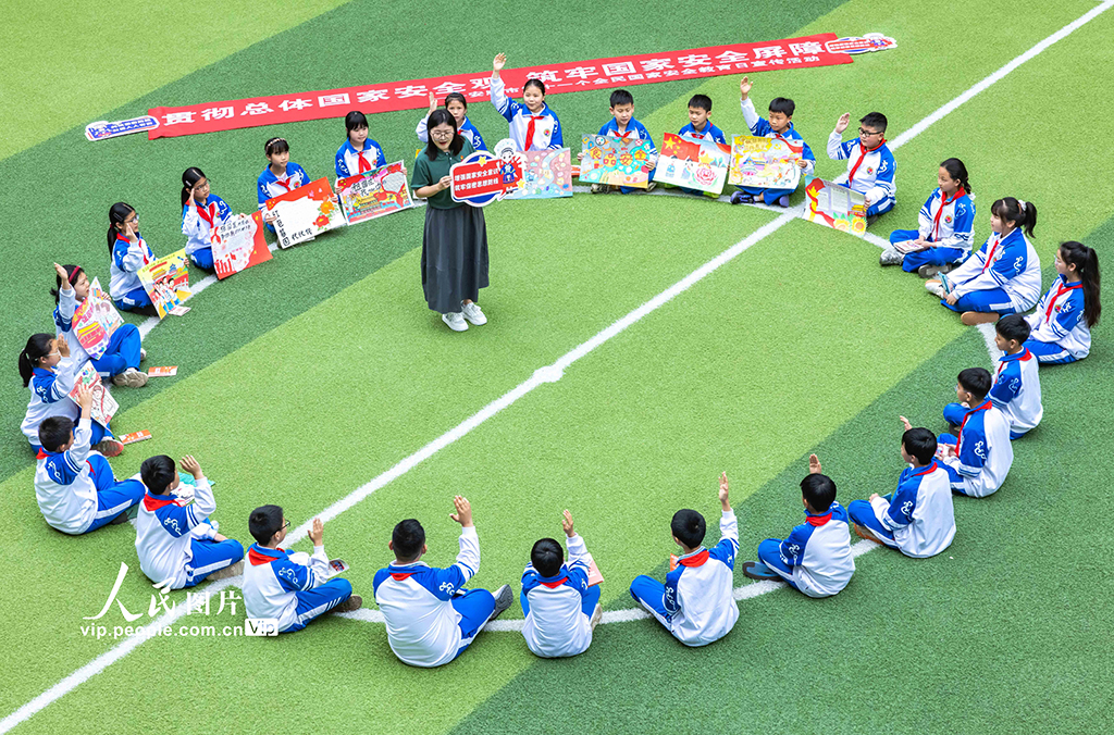 2026年4月14日，贵州安顺市国家保密局宣讲员在安顺市第七小学点评学生制作的“国家安全日”主题手抄报。4月15日是第十一个全民国家安全教育日，安顺市国家保密局联合市第七小学开展“统筹发展和安全 护航‘十五五’新征程”主题宣传教育活动，通过多种形式提升师生国家安全意识。陈熙摄（人民图片网）
