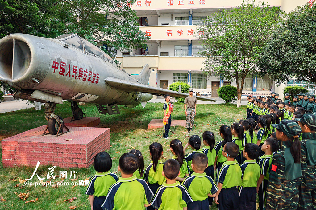 2026年4月14日，在广西贺州八步区龙山小学国防教育基地，学校红领巾讲解员正在为一年级学生讲解国防知识。龙山小学近日开展全民国家安全教育主题活动，通过主题队会、知识宣讲、艺术作品展、航模展示等形式，提升学生国防与国家安全意识，共同筑牢国家安全防线。黎豪图摄（人民图片网）
