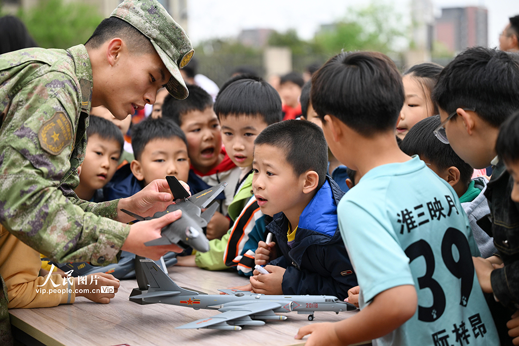 2026年4月13日，在安徽合肥淮河路第三小学，驻合肥部队官兵向小学生讲解装备模型，普及国家安全知识。庐阳区“安全‘童’行筑防线 国安护航向未来”全民国家安全教育日活动在该校举办。公安、消防等十余家单位走进校园，开展主题教育，宣传安全知识，增强师生国家安全意识。徐伟摄（人民图片网）