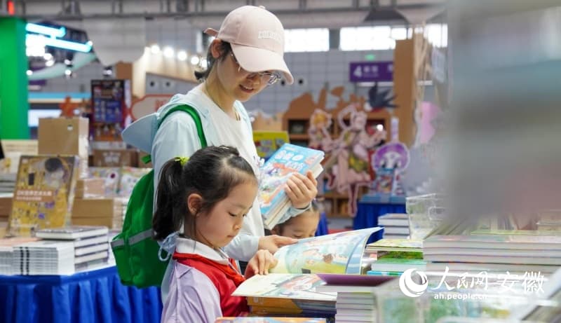 黄山书会现场,家长带着孩子挑选图书。人民网记者 陈若天摄