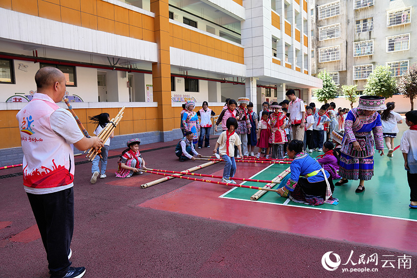 【1】昭通威信的暑期托管点位，本地艺术团教师带领学生体验竹竿舞。威信县融媒体中心供图