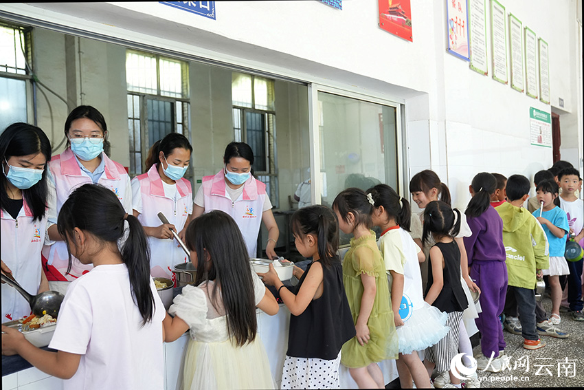 【5】在暑期托管点位，学生们排队打饭。威信县融媒体中心供图