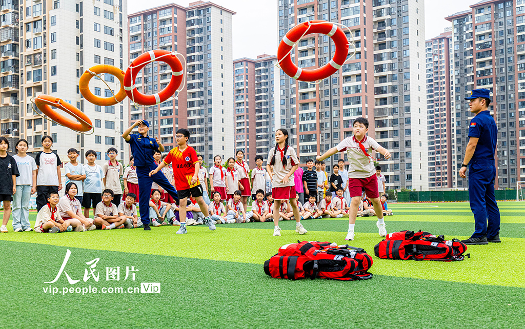 2026年6月23日，湖北黄石湖山小学，消防员指导学生正确使用救生圈。湖北黄石铁山区消防救援局消防员在汪仁镇湖山小学开展防溺水安全教育活动。学生在消防员指导下学习防溺水知识，增强暑期安全防范意识和应急自救互救能力，为学生夏日安全保驾护航。周巍摄（人民图片网）